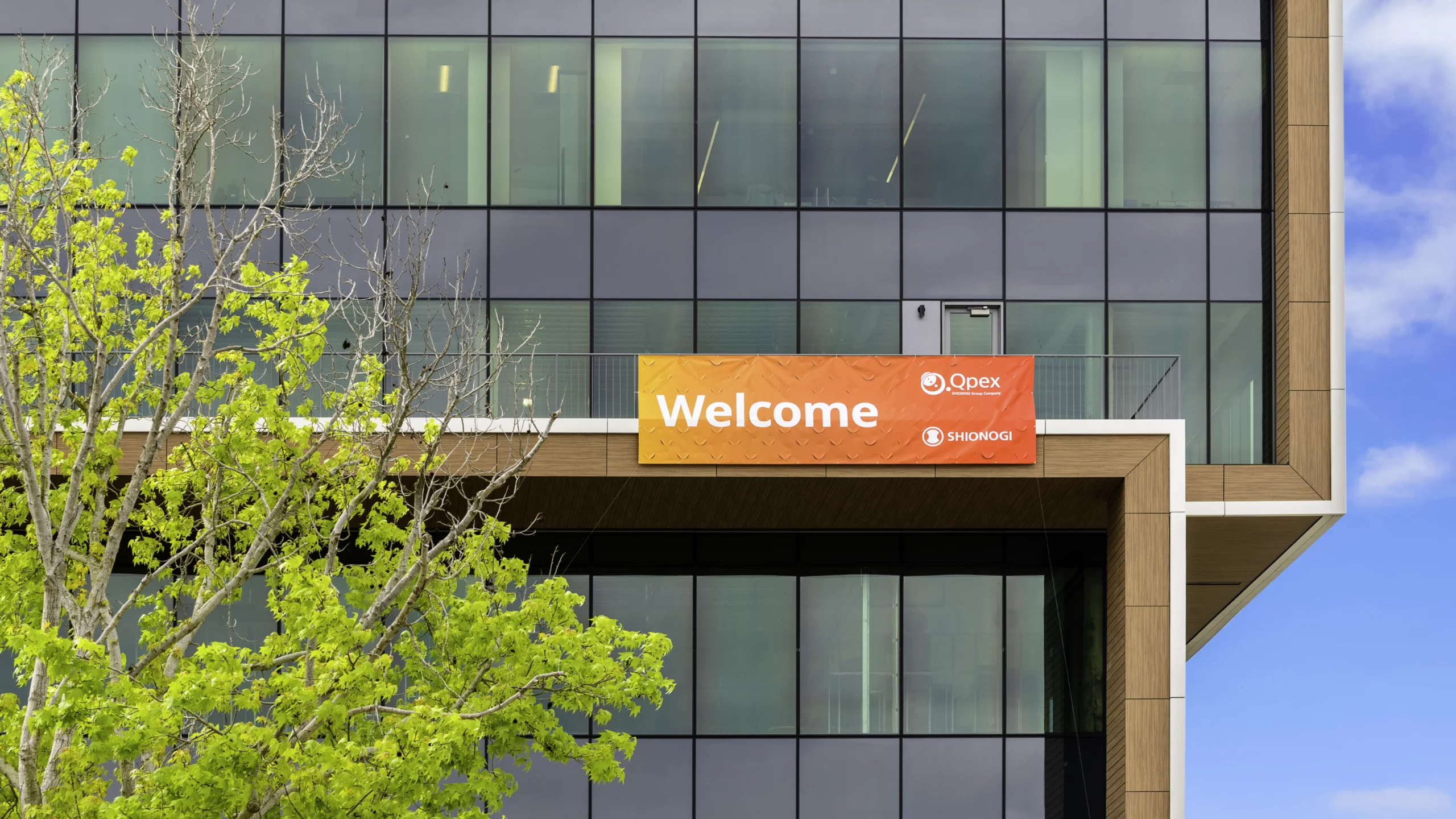 Welcome banner on the exterior of the Qpex building in San Diego.