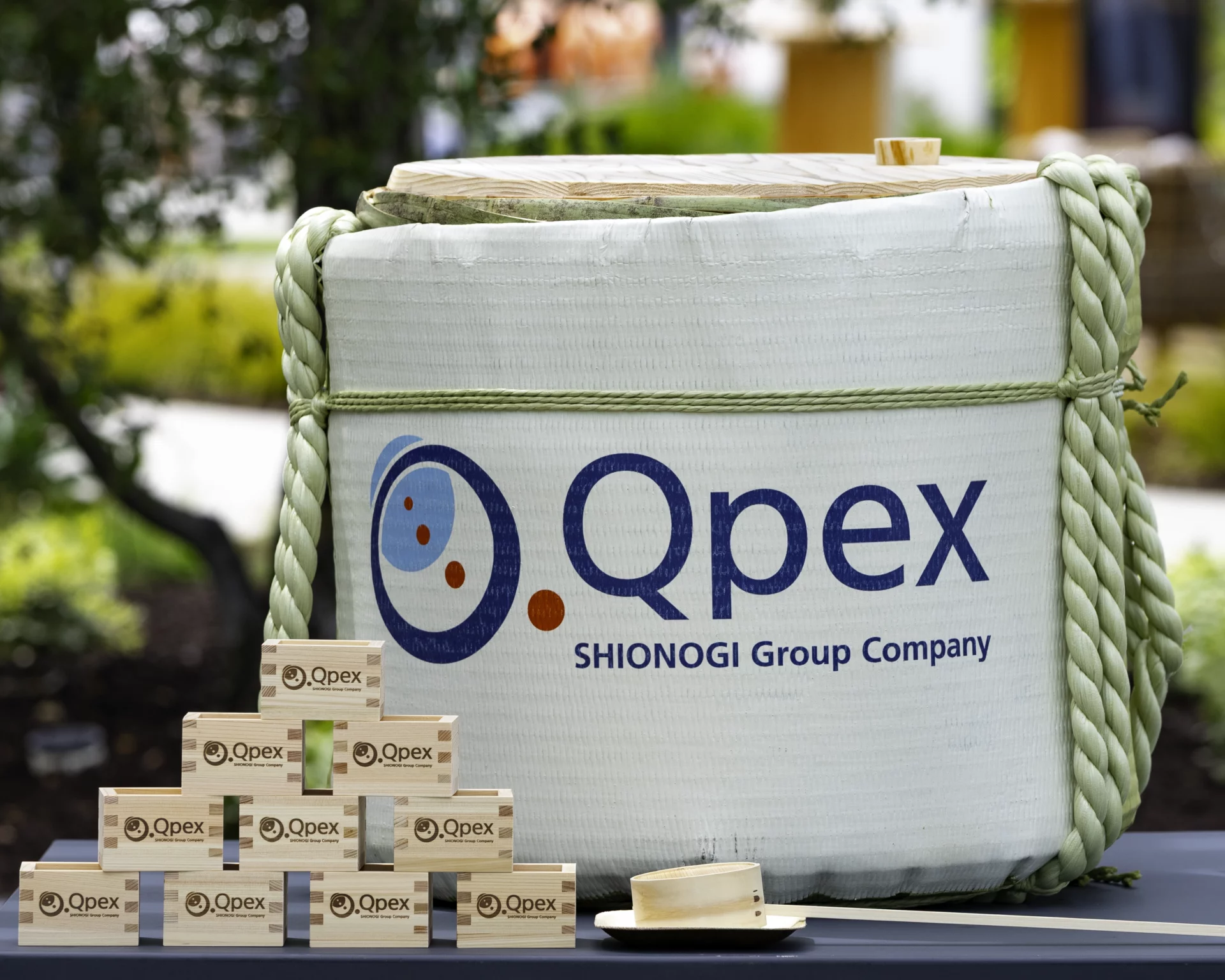 A sake barrel and traditional wooden sake cups featuring the Qpex logo were used in the kagami-biraki ceremony.
